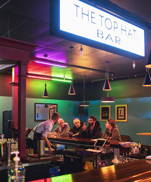 Inside The Top Hat Bar four people in background being entertained by bartender Inside The Top Hat Bar four people in background being entertained by bartender